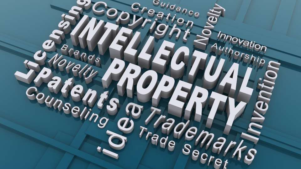 A 3D word cloud focused on the phrase "INTELLECTUAL PROPERTY" in large, white block letters. Surrounding the main text are related terms such as "Patents," "Copyright," "Trademarks," "Invention," "Authorship," and "Trade Secret." The words are arranged at various angles on a blue, textured background, visually representing the complex web of rights that researchers must navigate. This image underscores the section's message: clear boundaries must be established early to distinguish between the rights held by an individual and those claimed by a larger institution or university.