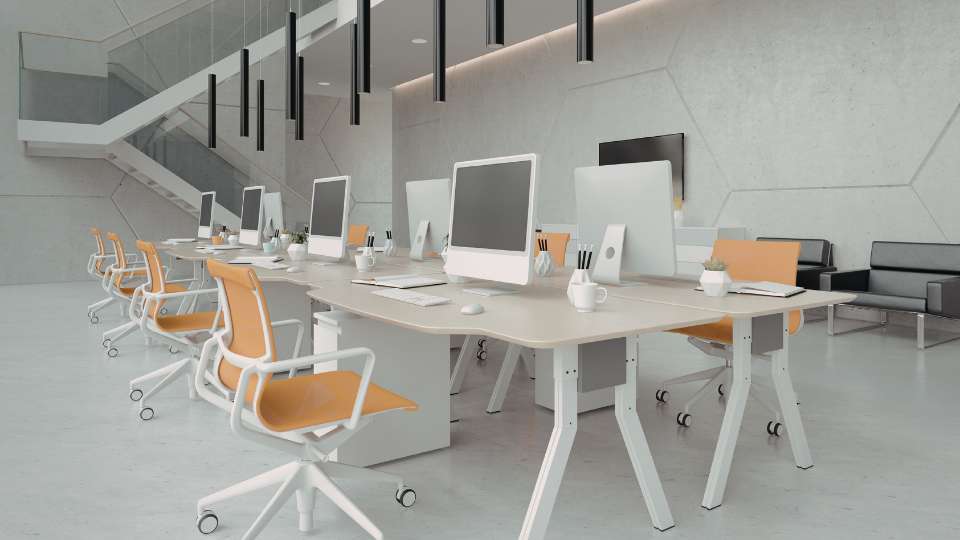 A modern, open-plan office with multiple workstations featuring large monitors at eye level. This ergonomic setup demonstrates the best practices for avoiding tech neck symptoms while performing intensive research for a long-term academic career.